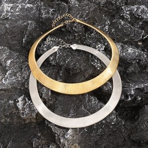 Vintage goldene und silberne Punk-Choker mit strukturiertem Metall auf dunklem Stein