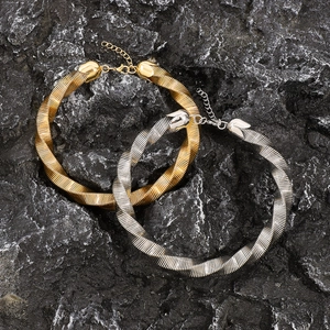 Grote geometrische gedraaide choker ketting in goud en zilver op zwarte vulkanische steen