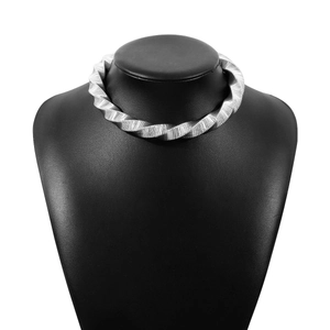 Macro-detail van zilveren gedraaide choker met industriële spiraalvormige texturen
