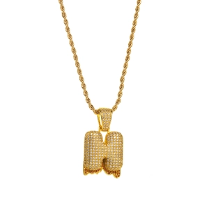 Macro view of iced out bubble letter H pendant with orange zircon drip and rope chain