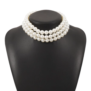 Elegant three-layer white pearl choker necklace displayed on a black jewelry stand