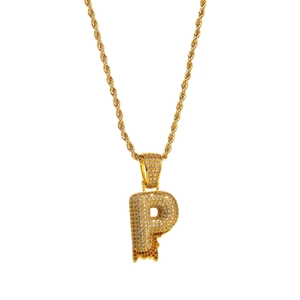 Macro detail of iced out letter P pendant with red dripping zircon on gold rope chain