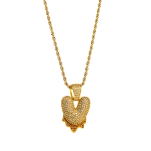 Close-up of golden bubble-style heart pendant with V letter and sparkling crystals