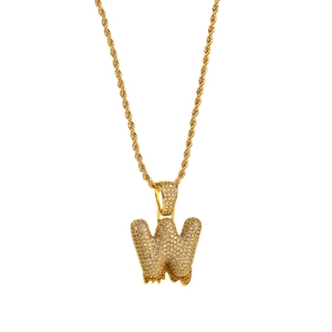 Macro detail of gold hip hop letter W pendant with sparkling zircons and rope chain