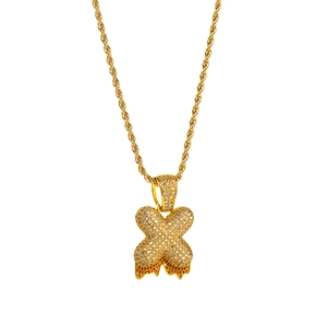 Close-up of hip hop gold rope chain with iced out X pendant and orange gemstone detail