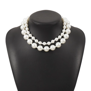 Elegant layered pearl necklace with oversized beads on a black neck bust stand