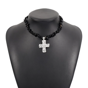 Dettaglio collana stile western con pietre nere e pendente a croce martellata