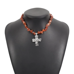 Dettaglio della collana con pietre irregolari e pendente a croce martellata