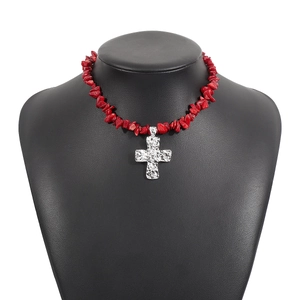 Dettaglio della collana boho con pietre rosse e pendente a croce in argento martellato