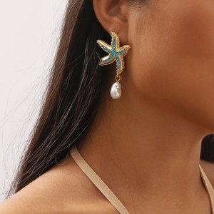 Starfish earrings with blue crystals and white baroque pearls on a female model