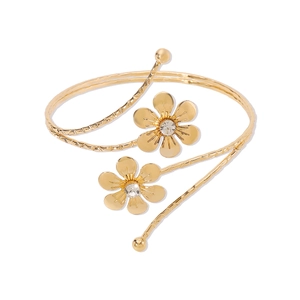 Detail of golden flower arm cuff featuring hammer texture and sparkling rhinestones