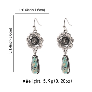 Detail showing vintage silver earrings with floral engraving and turquoise stones