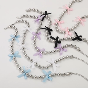 Close-up of metallic beaded necklaces with colorful silk bows and adjustable lobster clasps