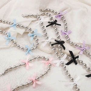 Close-up of beaded necklaces with colorful bows in blue, pink, purple, white and black