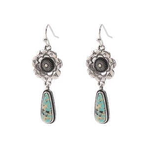 Detailed shot of vintage engraved silver earrings with turquoise teardrop pendants