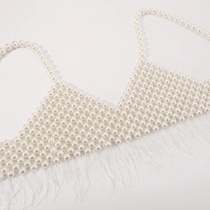 Detail of beaded pearl camisole featuring white feather trim and elegant V-neckline style