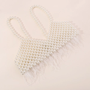 Detail of elegant white faux pearl beaded camisole top with fluffy feather fringe hem