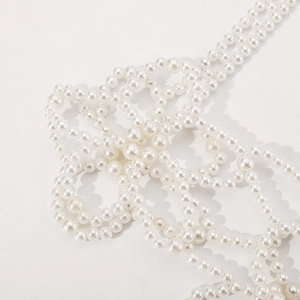 Détail du gilet en perles blanches fait main avec un motif de grille tissé élégant