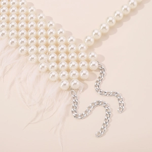 Detailed view of elegant multi-layer pearl body chain with white feather fringe accents