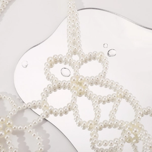 Détail d'une chaîne de corps en perles blanches faite main avec tissage floral raffiné