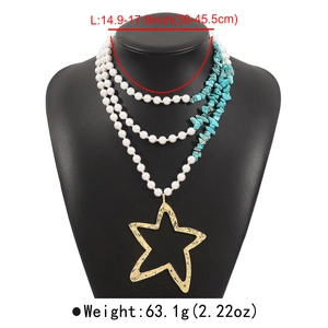 Détail du collier de perles et turquoise avec grand pendentif étoile de mer dorée