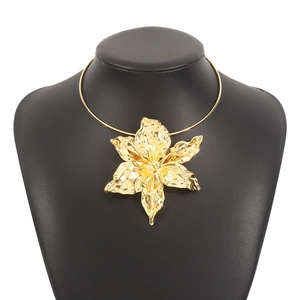 Detailed view of a large gold lily flower pendant on a sleek metal neck collar