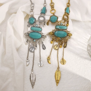 Detalle de collares bohemios de turquesa con colgantes de borlas metálicas en plata y oro