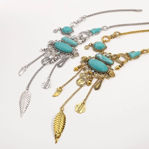 Detalle del collar bohemio con piedras turquesas y colgantes de monedas antiguas