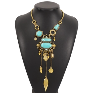 Primer plano del collar bohemio dorado con piedras turquesas y colgantes de hojas