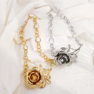 Detail van grove metalen ketting met 3D-rozenhanger in goud- en zilverkleurige afwerking