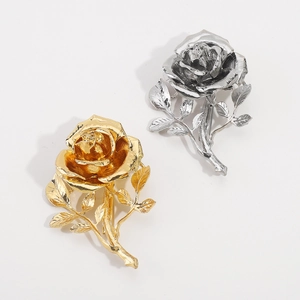 Detailweergave van 3D metalen rozenbroches in goud en zilver met elegante bladtextuur