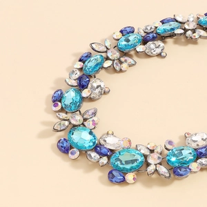 Macro view showing large oval cut blue crystals and intricate metalwork on the luxury necklace