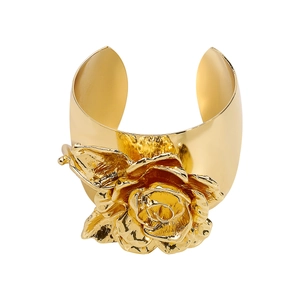 Macro-opname van een 3D-roos op een brede, gepolijste goudkleurige metalen armband