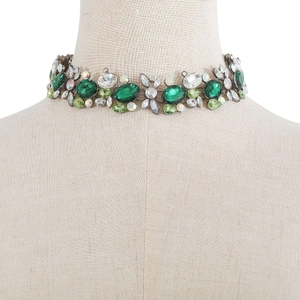 Detail of luxury vintage choker with emerald green crystals and multifaceted diamonds