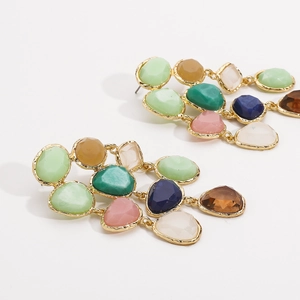Macro detail of bohemian resin drop earrings featuring colorful stone mosaic in gold setting