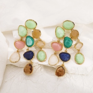 Detailed macro shot of bohemian multi-colored resin stone drop earrings in gold frame