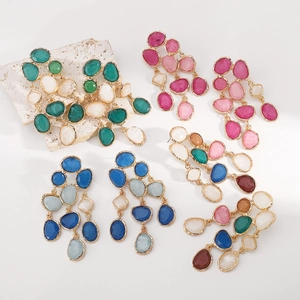 Detail of bohemian resin tassel earrings with colorful faceted gems and gold plating