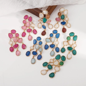 Flat lay of colorful resin drop earrings in diverse palettes on a white surface