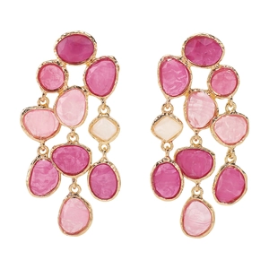 Close-up of bohemian tassel earrings with pink resin stones in gold metal settings