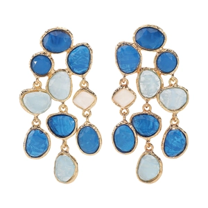 Detail of layered gold-tone earrings with multi-colored blue and white resin stones