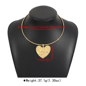 Détail du pendentif cœur doré avec gravure totem sur un collier ras du cou rigide en métal