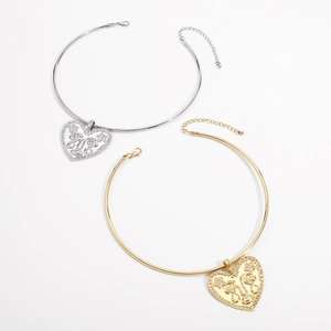 Vue détaillée des pendentifs cœur avec visages abstraits sur colliers rigides or et argent