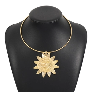 Vue détaillée du pendentif soleil doré en relief sur un collier torque pour femme