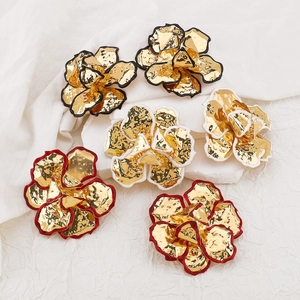 Detailopname van 3D vergulde bloemhangers met emaille randen en metalen textuur afwerking