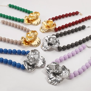 Detailed view of six colorful beaded necklaces with large metallic floral pendants