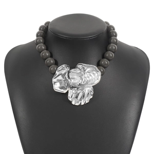 Detailed view of grey beaded necklace with large silver metal flower pendant on black bust