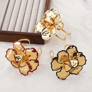 Vintage bloemmanchetarmbanden met gouden textuur en zwarte emaille randafwerking