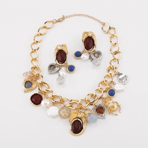 Dettaglio di un set di gioielli vintage in lega dorata con perle e pietre preziose