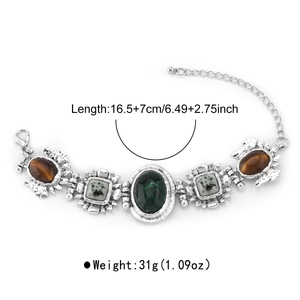 Detail eines Vintage-Barock-Armbands mit smaragdgrünen und braunen Steinen auf weißem Grund