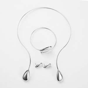 Detalle del juego de joyas plateadas con collar, pulsera y pendientes de gota de agua